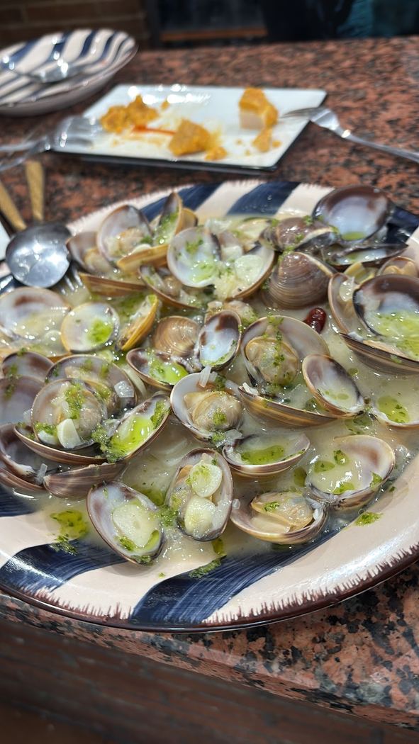 Almejas al ajillo, un plato tradicional servido en cazuela de barro.